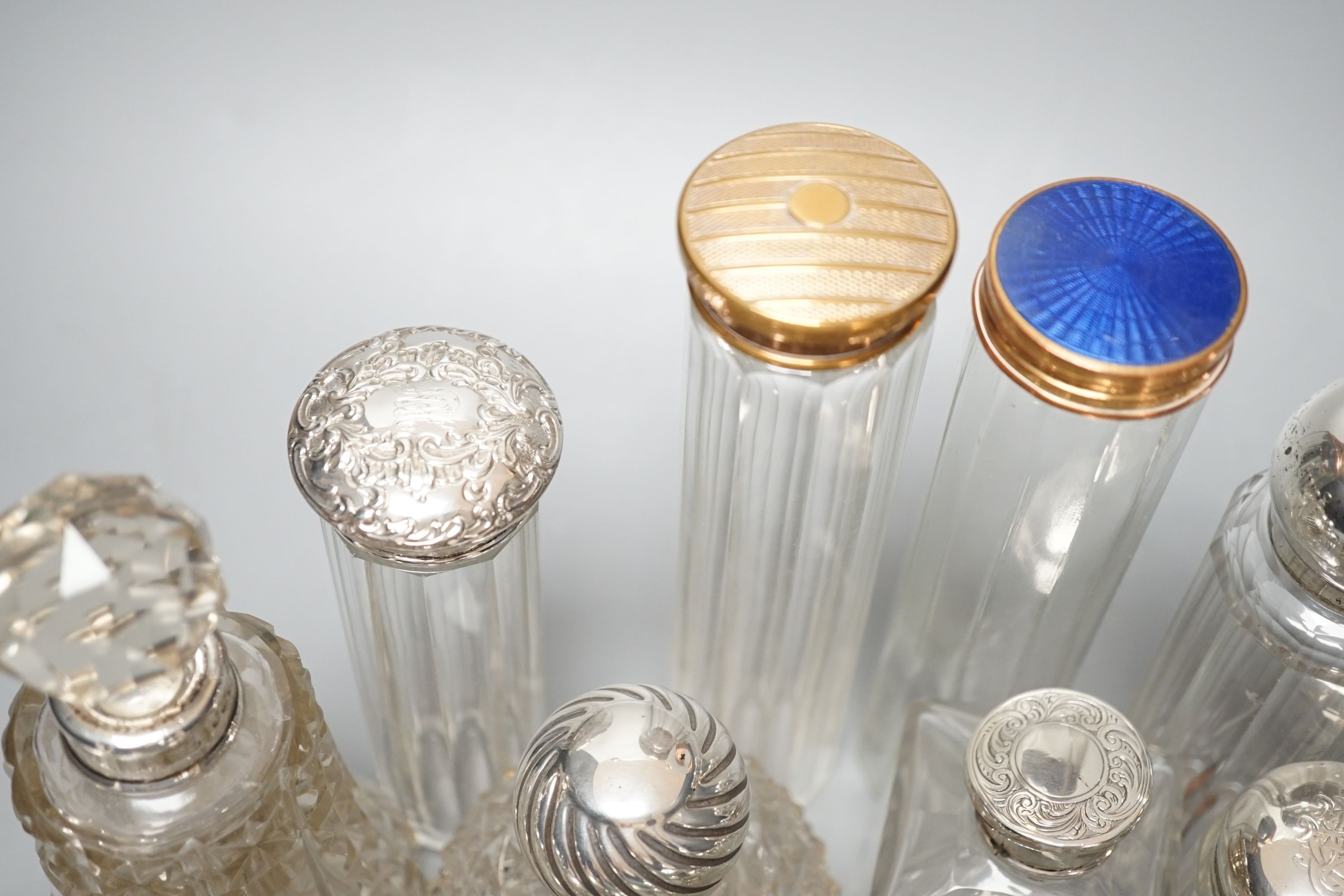 A collection of assorted mainly silver-capped scent bottles and toilet bottles.